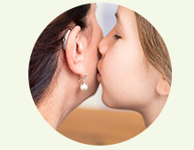 bambina che parla nell orecchio di una donna con apparecchio acustico