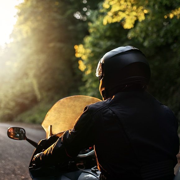 Motorradfahrer am Waldrand