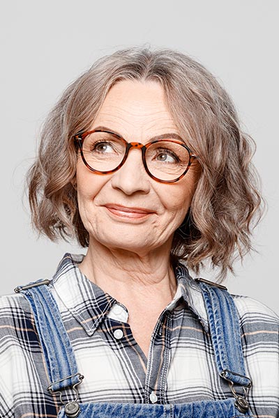 Middle aged woman with glasses and overalls