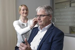 En mand bærer høreapparat